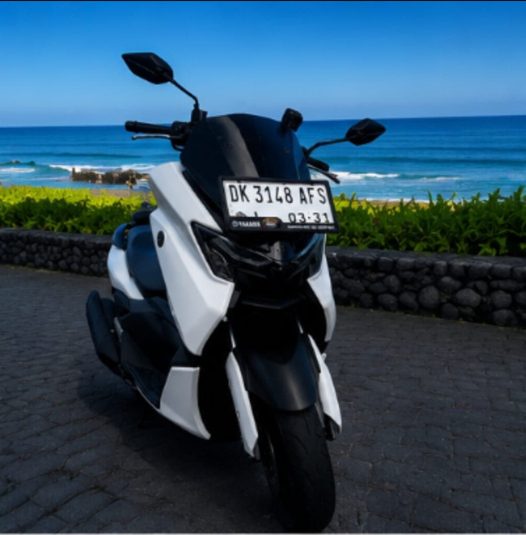 A Yamaha NMAX scooter from Benz Rental Bali's fleet, parked overlooking the coast in Bali